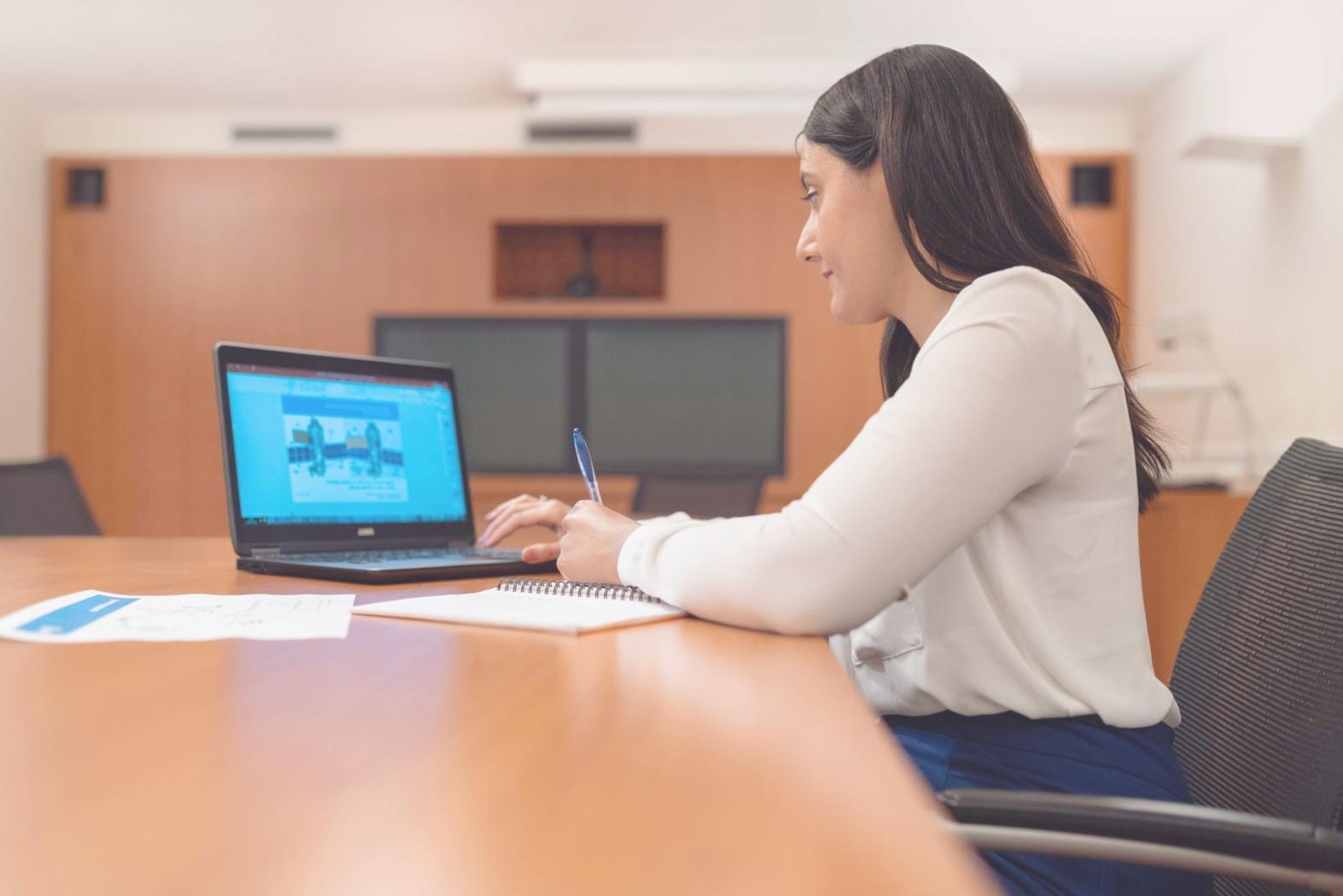 Person reviewing financial documents and data on computer screen